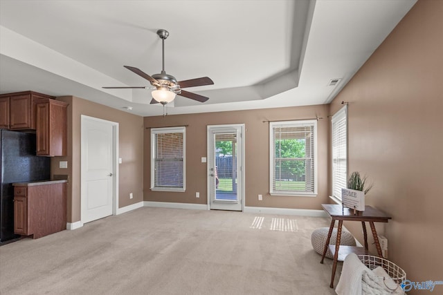 5008 Montauk Trl, Owens Cross Roads, AL 35763 - living room featuring a raised ceiling, a ceiling fan, baseboards, and light carpet