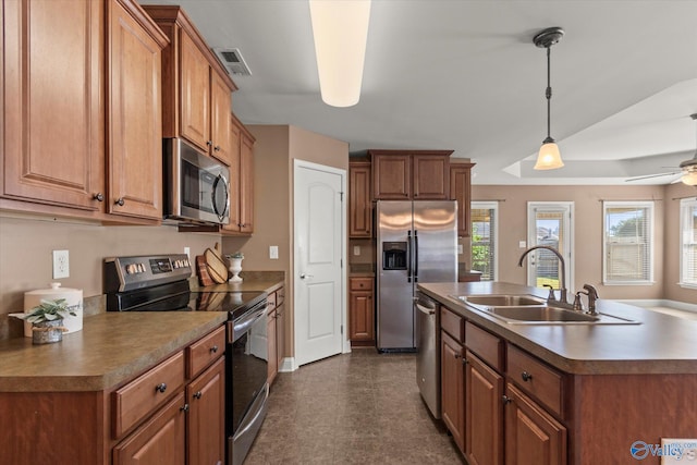 5008 Montauk Trl, Owens Cross Roads, AL 35763 - kitchen with appliances with stainless steel finishes, a sink, brown cabinets, a kitchen island with sink, and ceiling fan