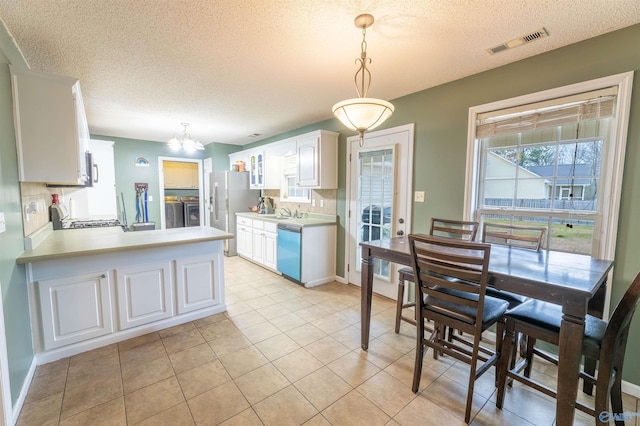 kitchen with light countertops, pendant lighting, white cabinetry, and visible vents