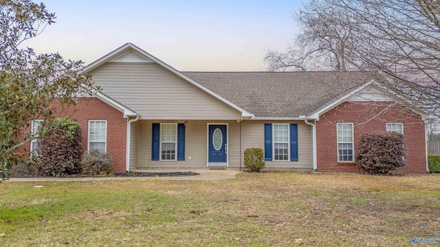 single story home featuring brick siding and a front yard