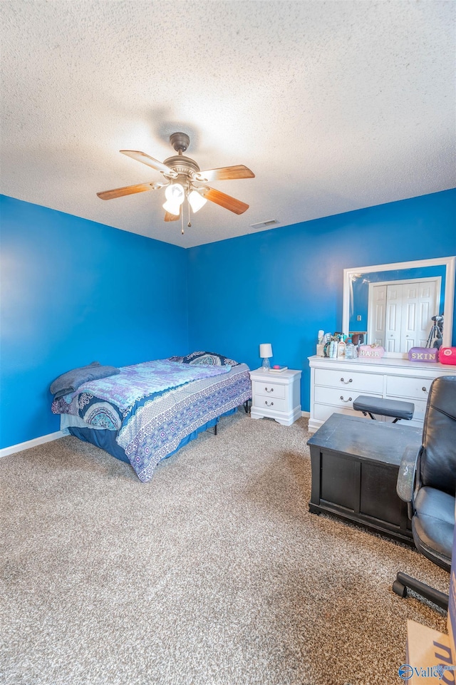 bedroom with a textured ceiling, carpet, visible vents, and baseboards