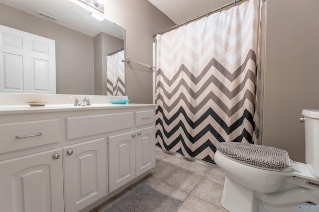 bathroom featuring a textured ceiling, tile patterned flooring, toilet, vanity, and visible vents