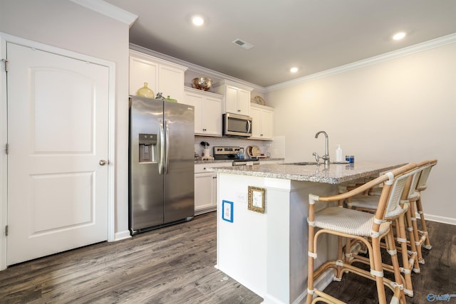 kitchen featuring a sink, stainless steel appliances, visible vents, and dark wood finished floors