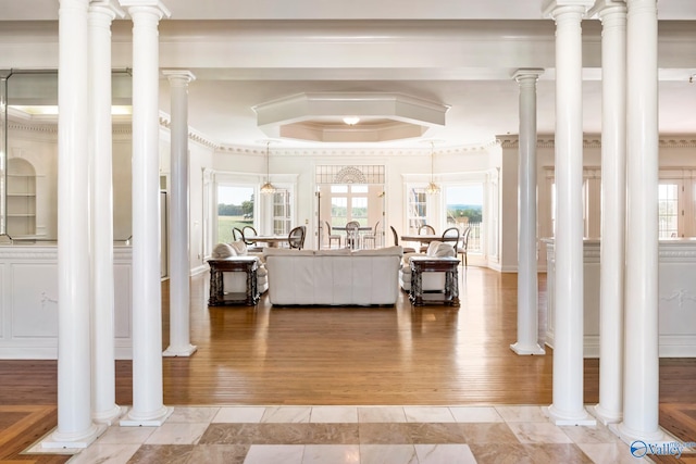 interior space with decorative columns, hardwood / wood-style flooring, and crown molding