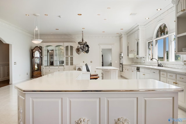 kitchen with light tile patterned flooring, hanging light fixtures, sink, dishwasher, and a spacious island