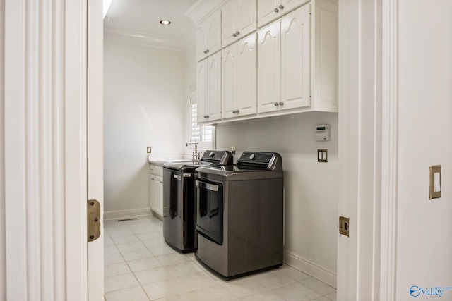 washroom with cabinets, light tile patterned floors, crown molding, and washing machine and clothes dryer