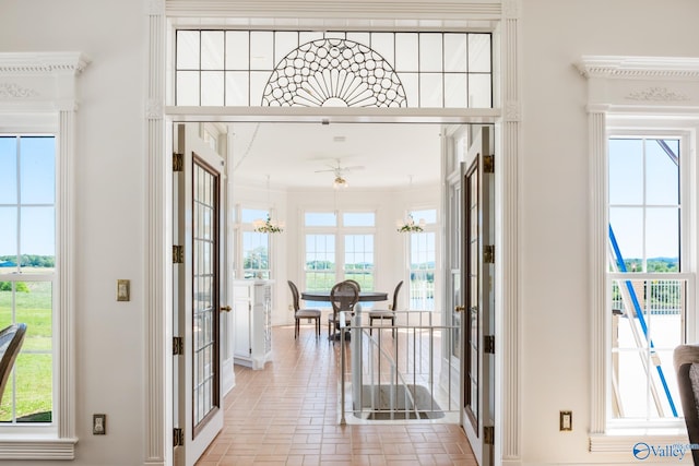 doorway to outside with french doors, a wealth of natural light, and ornamental molding