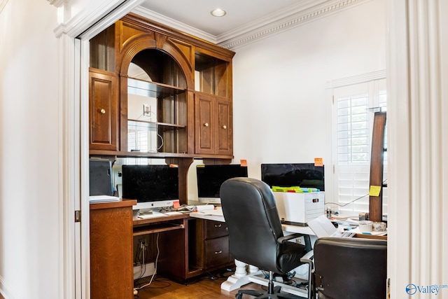 home office with wood-type flooring, crown molding, and built in desk