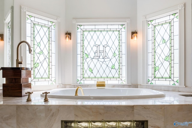 bathroom with plenty of natural light and tiled tub