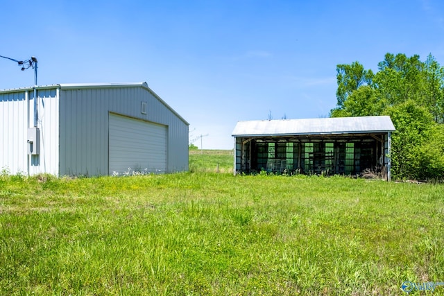 view of yard with a garage and an outbuilding