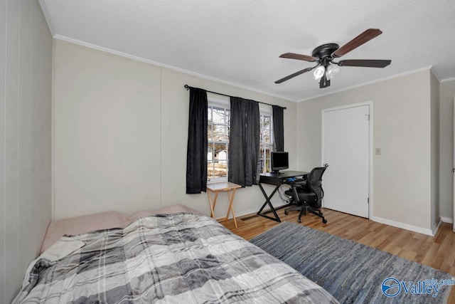 bedroom with baseboards, ceiling fan, ornamental molding, and wood finished floors