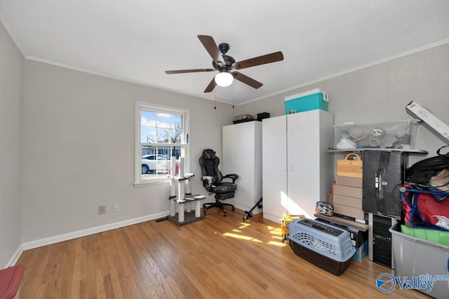 interior space with baseboards, ornamental molding, ceiling fan, and wood finished floors