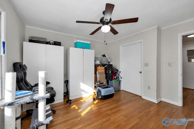 interior space with a ceiling fan, crown molding, baseboards, and hardwood / wood-style floors