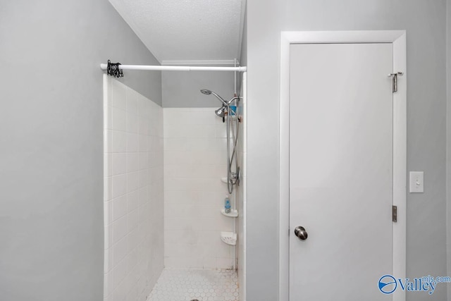 bathroom with a stall shower and a textured ceiling