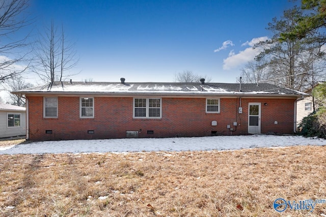 back of property featuring crawl space and brick siding