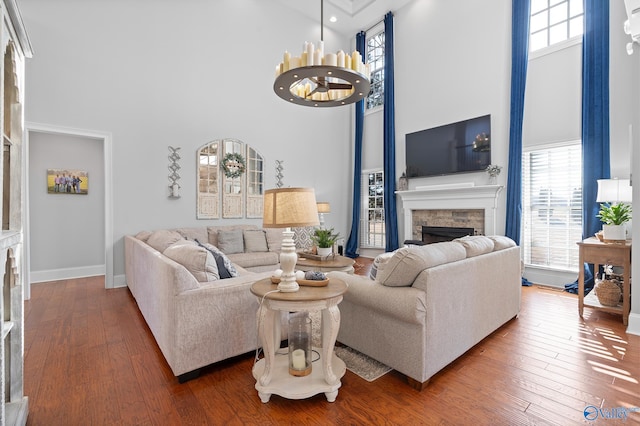 living room featuring a chandelier, a high ceiling, and wood-type flooring