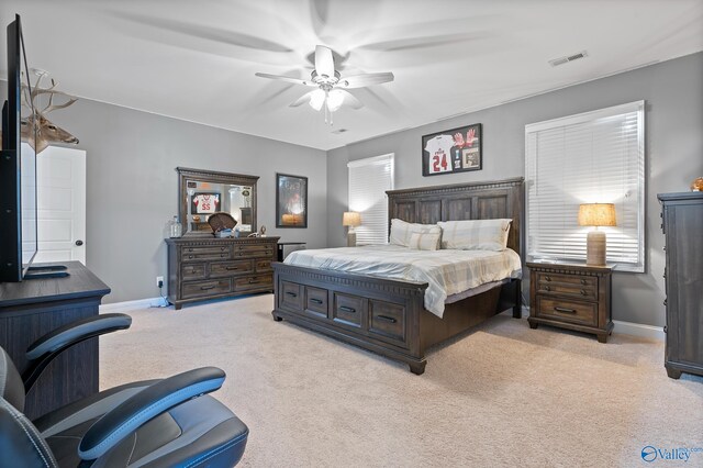 bedroom featuring ceiling fan, multiple windows, and light carpet