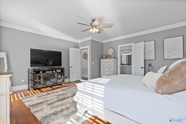 bedroom with ceiling fan, sink, hardwood / wood-style flooring, ornamental molding, and connected bathroom