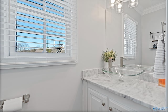 bathroom featuring an inviting chandelier, vanity, and ornamental molding