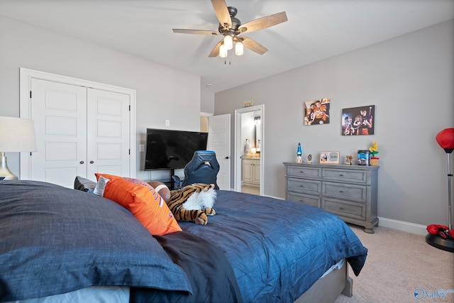 carpeted bedroom with a closet, ceiling fan, and ensuite bath