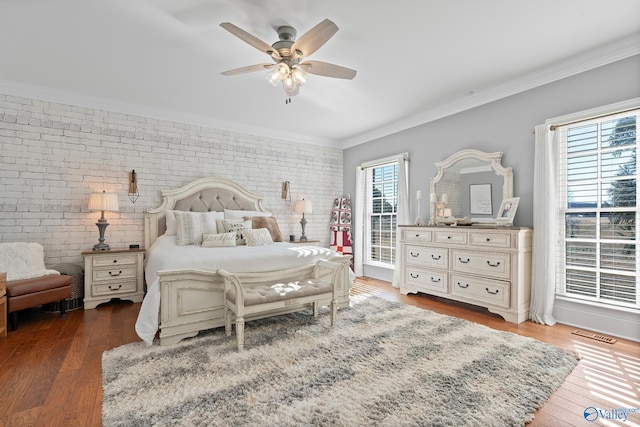 bedroom featuring ceiling fan, brick wall, dark wood-type flooring, and multiple windows