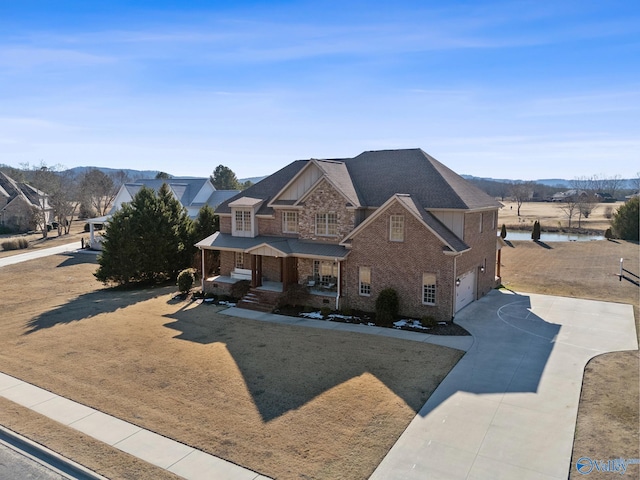 view of front of house featuring a garage, a front lawn, a mountain view, and covered porch