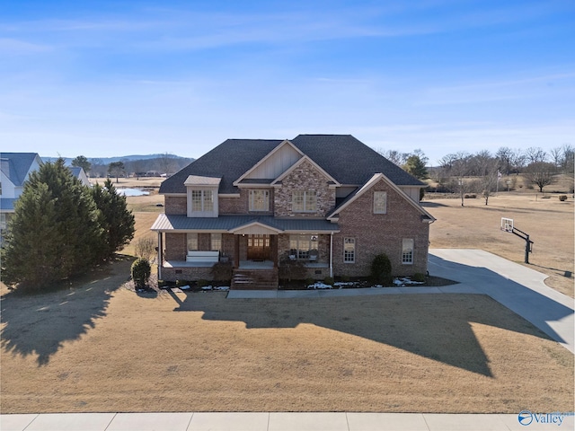 view of front of house featuring a mountain view, a front yard, and a porch