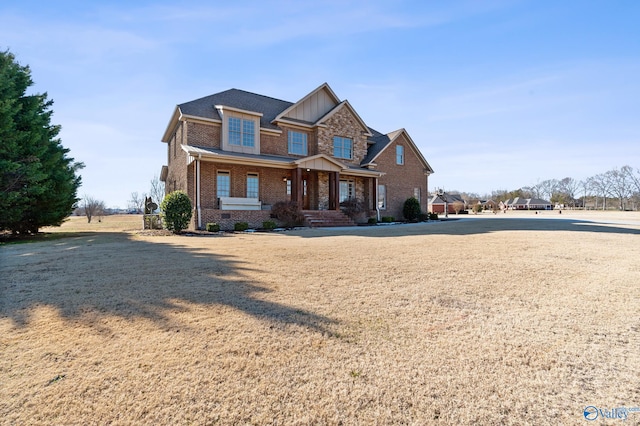 craftsman-style home featuring covered porch and a front lawn