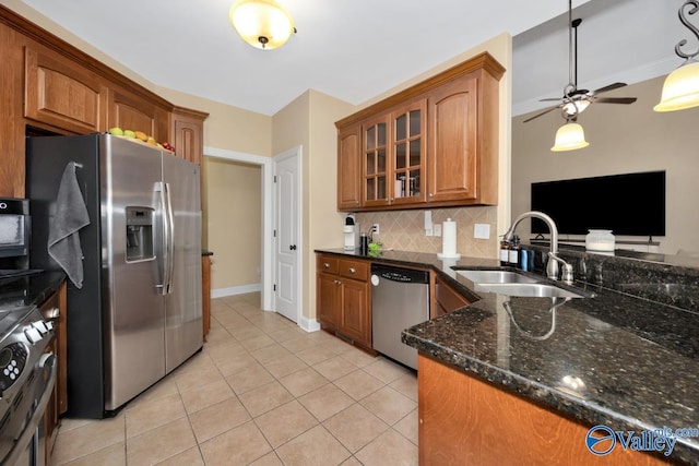 kitchen featuring tasteful backsplash, sink, light tile patterned floors, and appliances with stainless steel finishes