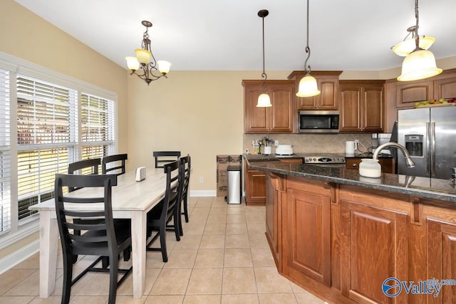 kitchen with stainless steel appliances, tasteful backsplash, a notable chandelier, decorative light fixtures, and light tile patterned floors