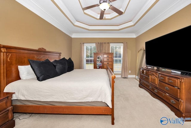 carpeted bedroom with a tray ceiling, ceiling fan, and crown molding