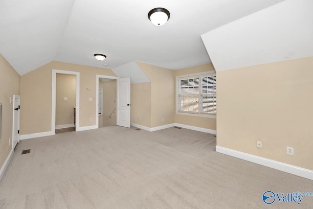 additional living space with light carpet and vaulted ceiling