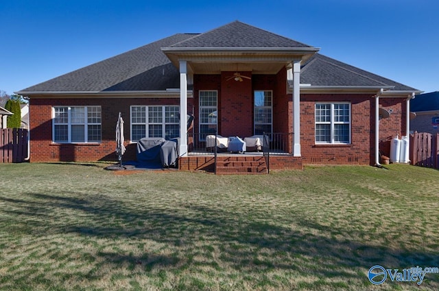 rear view of property with outdoor lounge area, ceiling fan, and a yard