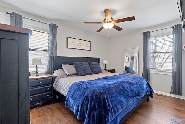 bedroom with visible vents, baseboards, a ceiling fan, and dark wood-style floors