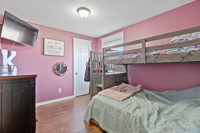 bedroom with baseboards and wood finished floors