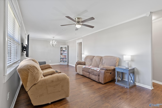living area featuring ceiling fan with notable chandelier, wood finished floors, baseboards, and ornamental molding