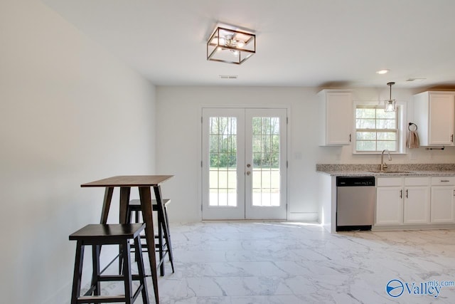 kitchen featuring pendant lighting, sink, dishwasher, white cabinetry, and french doors