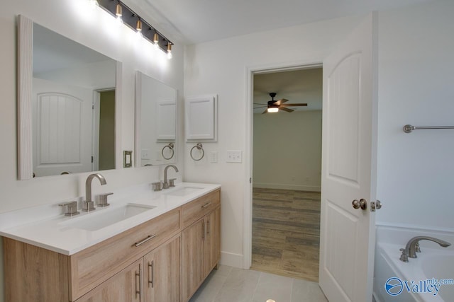 bathroom with ceiling fan, vanity, and a washtub