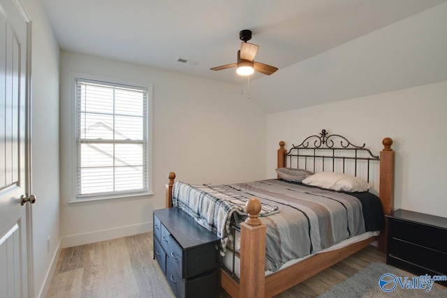 bedroom featuring hardwood / wood-style flooring, vaulted ceiling, and ceiling fan