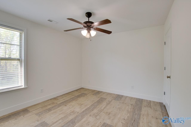 spare room featuring ceiling fan, light hardwood / wood-style floors, and a wealth of natural light