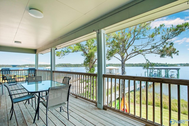 wooden terrace featuring outdoor dining area and a water view