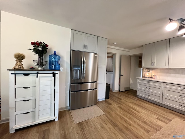 229 Crawford Rd, Scottsboro, AL 35769 - kitchen with stainless steel fridge with ice dispenser, light wood finished floors, light countertops, backsplash, and baseboards