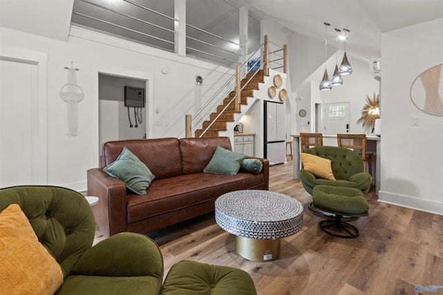 living room with high vaulted ceiling and wood-type flooring