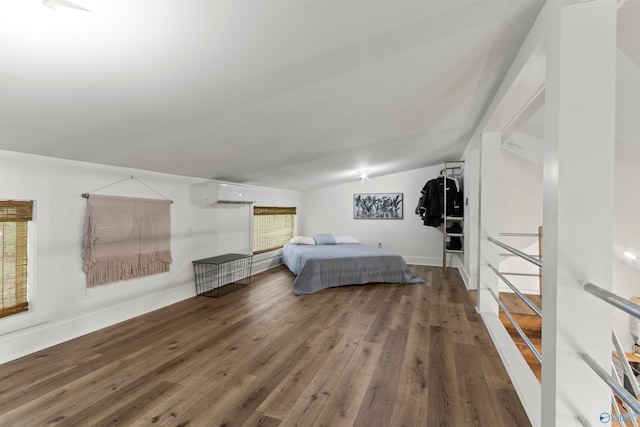 bedroom with a wall mounted air conditioner, wood-type flooring, and vaulted ceiling