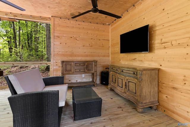 interior space with ceiling fan, wood ceiling, wooden walls, and light hardwood / wood-style flooring