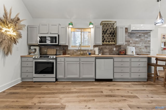 kitchen with hanging light fixtures, gray cabinets, sink, and stainless steel appliances