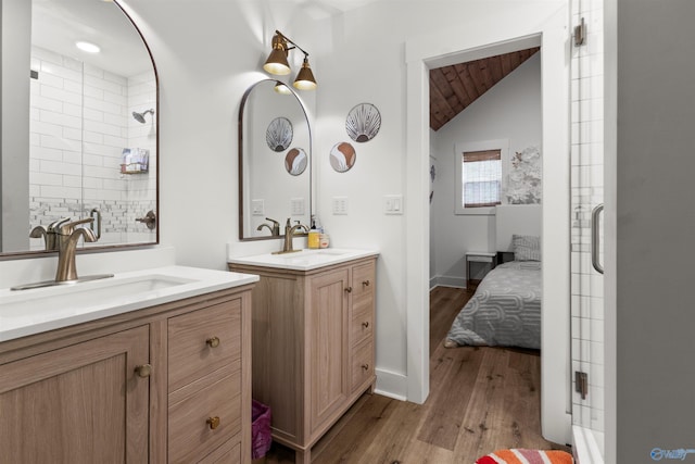 bathroom with hardwood / wood-style floors, vanity, and vaulted ceiling