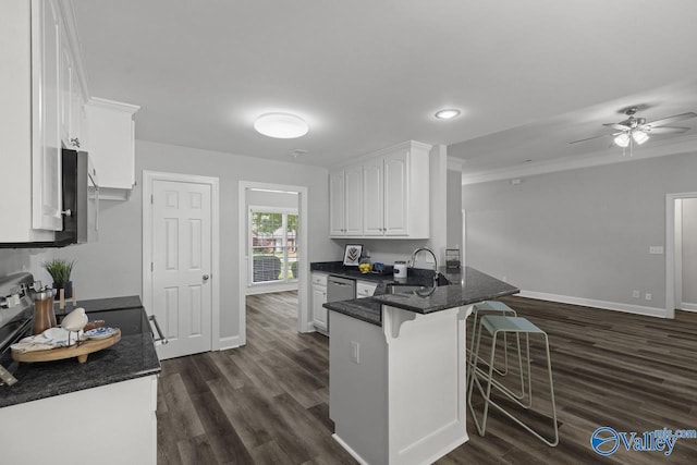 2624 Bransford Trl, Owens Cross Roads, AL 35763 - kitchen featuring white cabinets, a peninsula, a sink, a kitchen breakfast bar, and dark wood-style flooring