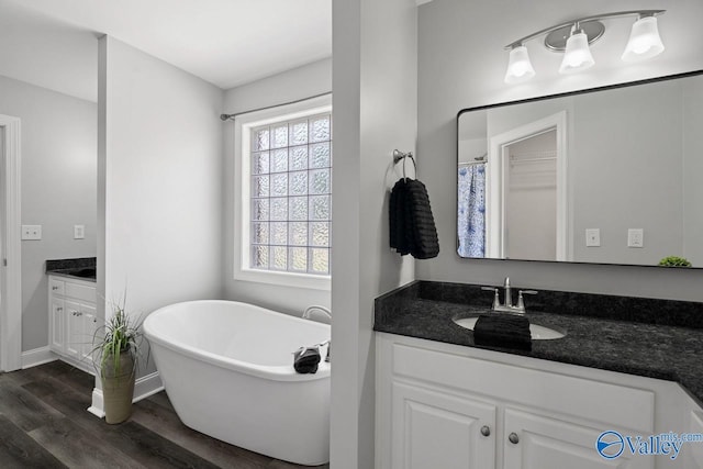2624 Bransford Trl, Owens Cross Roads, AL 35763 - full bathroom with wood finished floors, vanity, a soaking tub, and baseboards