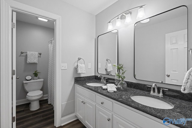 2624 Bransford Trl, Owens Cross Roads, AL 35763 - full bathroom featuring wood finished floors, double vanity, toilet, and baseboards